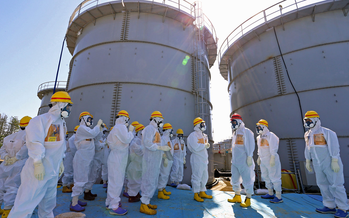 Japanese Prime Minister Shinzo Abe was briefed on the situation at the Fukushima Dai-ichi nuclear power plant as he toured the facility back on Sept. 19, 2013.  chief Akira Ono (4th L) in front of two tanks (back) which are being dismantled after leaking contaminated water, during his tour to the tsunami-crippled plant in Okuma, Fukushima Prefecture, northeastern Japan on September 19, 2013. Abe told Fukushima's operator to fix radioactive water leaks as he toured the crippled nuclear plant on September 19, less than two weeks after assuring the world the situation was under control. AFP PHOTO / Japan Pool  JAPAN OUT        (Photo credit should read JAPAN POOL/AFP/Getty Images)